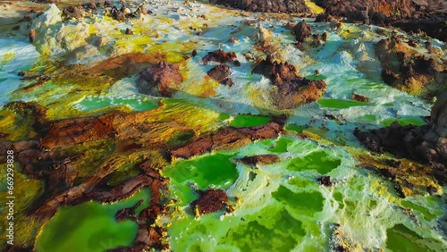 Dallol volcano, Danakil Depression, Ethiopia. Low altitude aerial view of colorful sulfur ponds. Cinematic drone footage at sunrise. Amazing natural landscape. Famous travel destination landmark.
