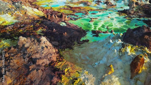 Dallol volcano, Danakil Depression, Ethiopia. Low altitude aerial view of colorful sulfur ponds. Cinematic drone footage at sunrise. Incredible natural landscape. Famous travel destination landmark.