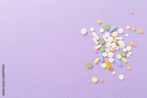 Different medical pills and capsules on color background  top view
