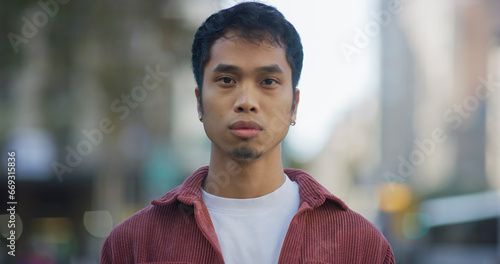 Fotografía Young Filipino man serious face portrait on city street