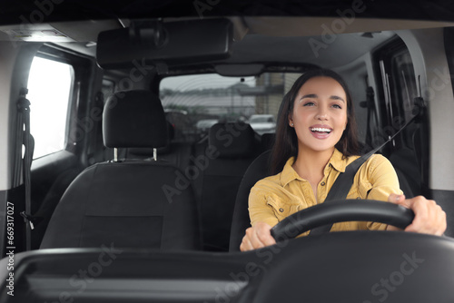 Listening to radio. Beautiful woman enjoying music in car, view through windshield