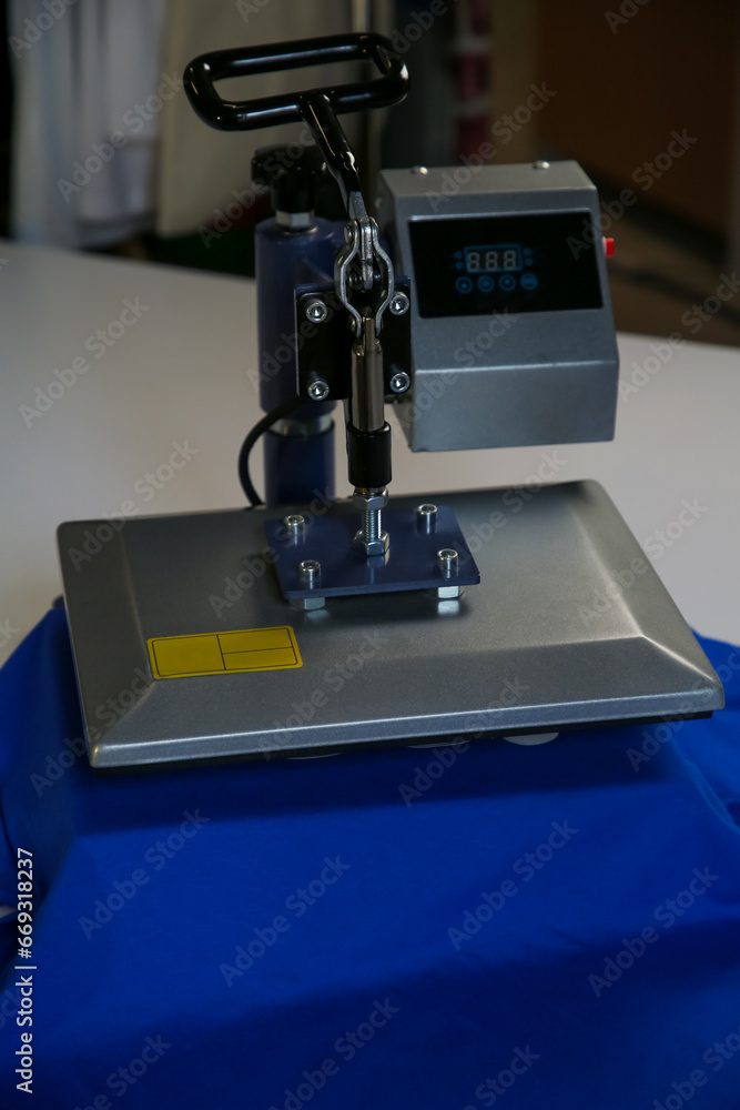 Fototapeta premium Printing logo. Heat press with t-shirt on white table