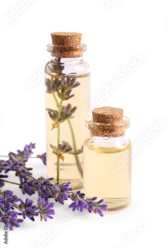 Essential oil and lavender flowers on white background