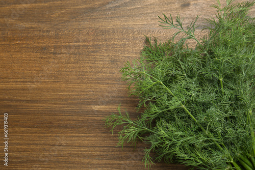 Fresh green dill on wooden table, top view. Space for text