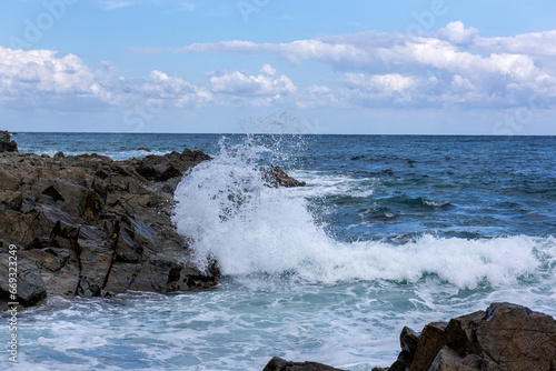 Large ocean big power wave crashing onto a rock beach 