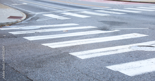crosswalk on urban street, painted white lines symbolize safety and community, pedestrians crossing, city life, traffic, pedestrian-friendly environment, road safety, walking, urban infrastructure