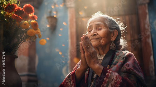 Obraz na płótnie Elderly woman with intricate earrings, praying serenely beside a vase of vibrant marigold flowers against a rustic backdrop w salonie