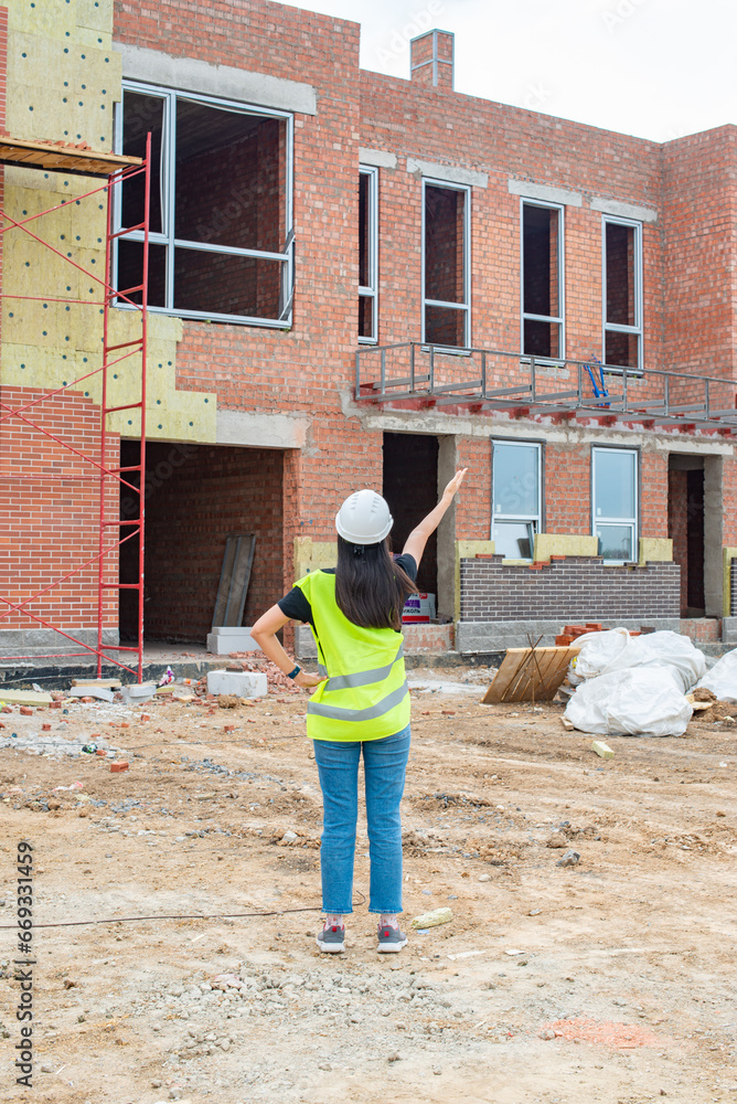 One girl in overalls came to the construction site. High quality photo