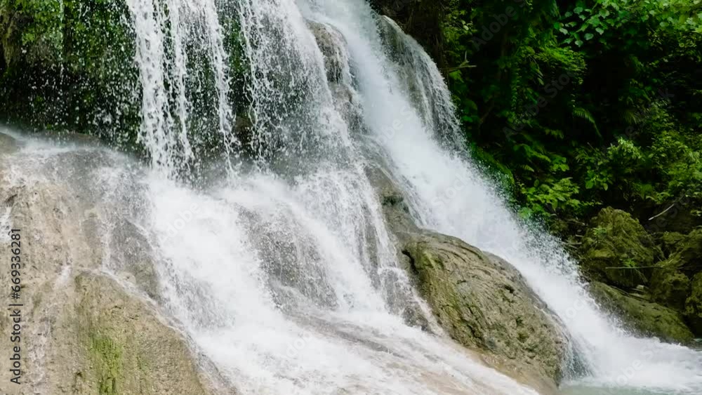 Waterfall in the green forest in slow motion. Lusno Falls in the jungle. Cebu, Philippines. Waterfall in the green forest in slow motion. Lusno Falls in the jungle. Cebu, Philippines.