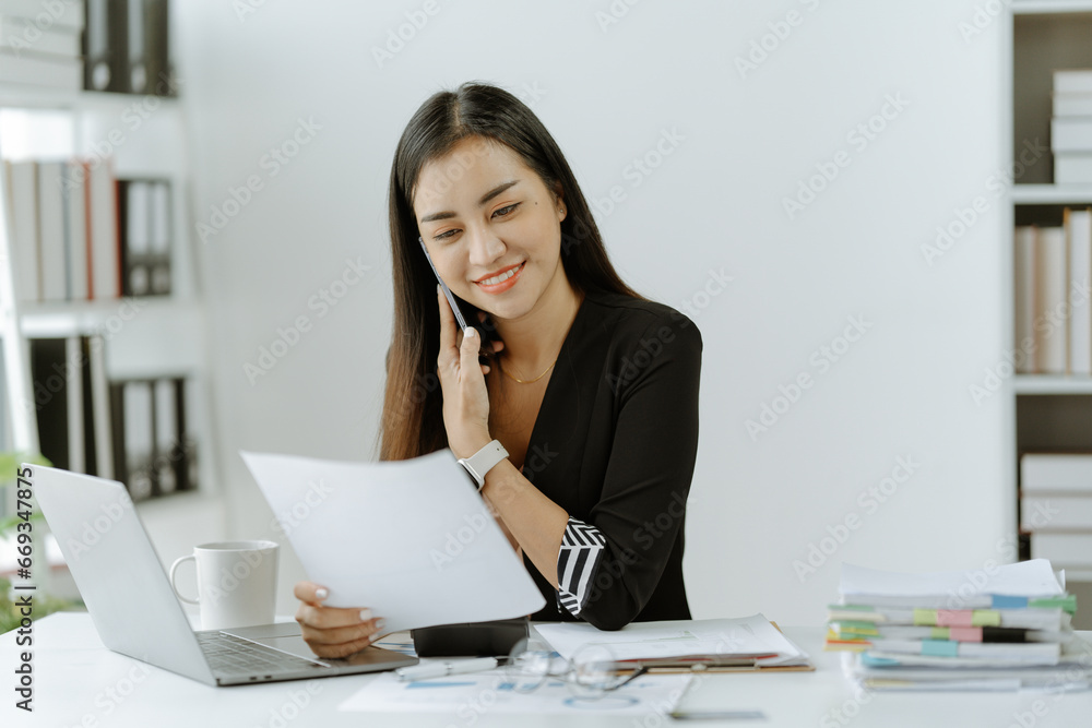 Asian woman sitting at a desk working in the office use a computer, laptop Asian woman sitting at a desk working in the office use a computer, laptop