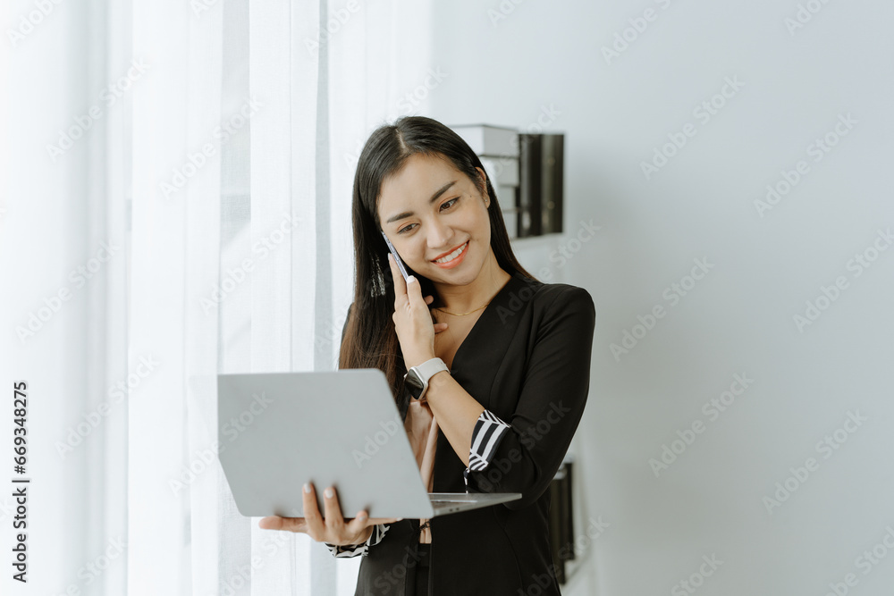 Asian woman sitting at a desk working in the office use a computer, laptop Asian woman sitting at a desk working in the office use a computer, laptop