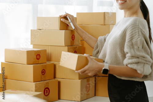 Small start-up business owners checking parcels at work, salespeople, checking production orders. Pack products for delivery to customers Sell ​​Ecommerce Shipping Ideas © Kritdanai