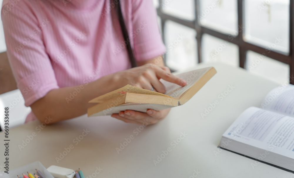 Asian girl student reading book preparing for college exam Youn Asian girl student reading book preparing for college exam Youn