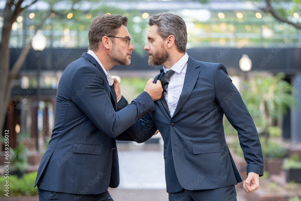 Businessmen fighting outdoor. Angry office workers in city. Disagreed men partners. Business competition. Business fight. Business men aggressive outdoor. Colleagues aggressive disagreement. Businessmen fighting outdoor. Angry office workers in city. Disagreed men partners. Business competition. Business fight. Business men aggressive outdoor. Colleagues aggressive disagreement.