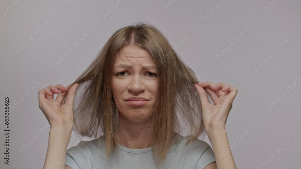 A woman shows her thin bad hair. Thinning and hair loss. Emotional disorders