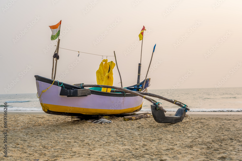 Fototapeta premium old fishing boats in the sand on the ocean in India on blue sky background