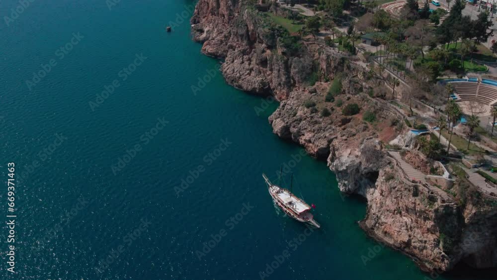 Aerial view of rocky coastline with boat near old city of Antalya Turkey.