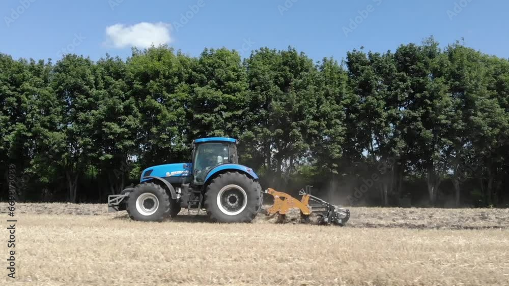 Tractor on the field plowing after wheat harvest Tractor on the field plowing after wheat harvest