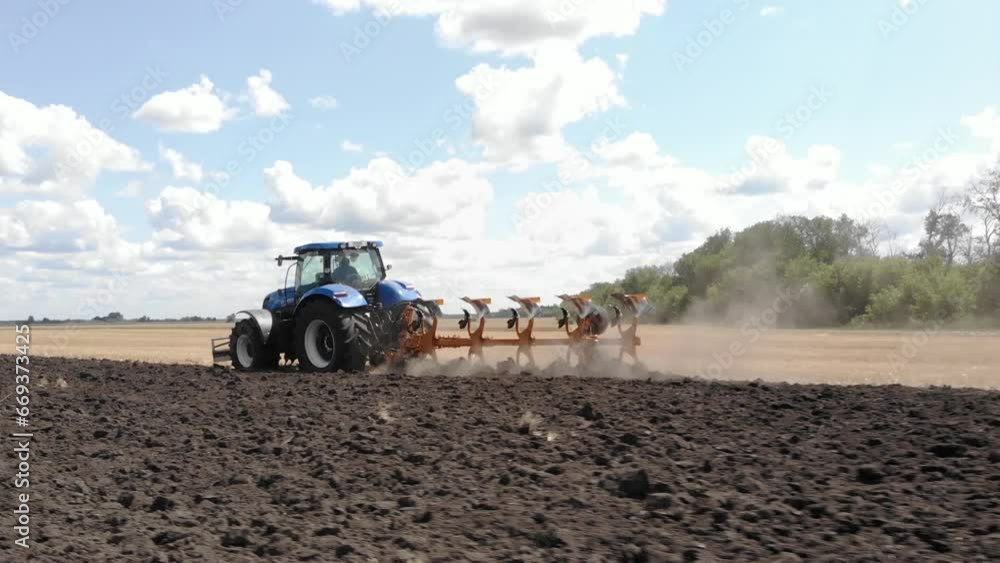 Tractor on the field plowing after wheat harvest Tractor on the field plowing after wheat harvest