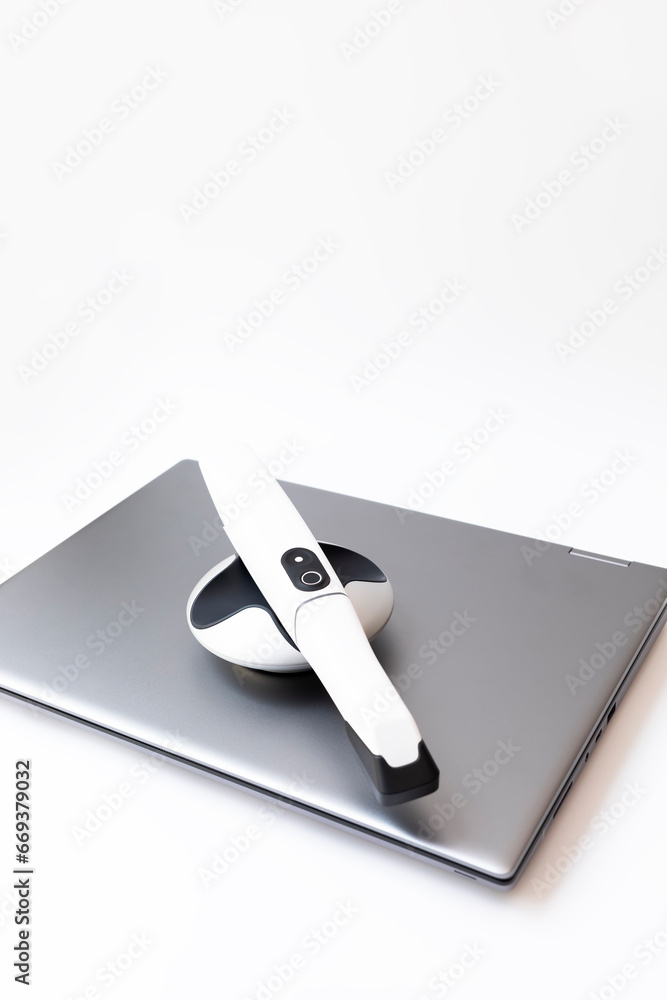 Isolated 3D Tooth Scanner For Imaging Teeth on Computer, Notebook. White 3d Intraoral Dental Teeth Scanner Lying on Table. Dental Equipment, Device For Scanning Teeth. Dentistry. Vertical Plane Isolated 3D Tooth Scanner For Imaging Teeth on Computer, Notebook. White 3d Intraoral Dental Teeth Scanner Lying on Table. Dental Equipment, Device For Scanning Teeth. Dentistry. Vertical Plane