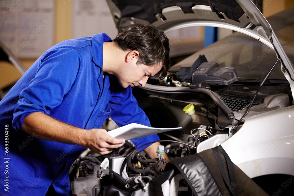 Car, service and repair with a mechanic man in a workshop as an engineer looking at the engine of a vehicle. Garage, report or quote with a young technician working under the hood of an automobile Car, service and repair with a mechanic man in a workshop as an engineer looking at the engine of a vehicle. Garage, report or quote with a young technician working under the hood of an automobile