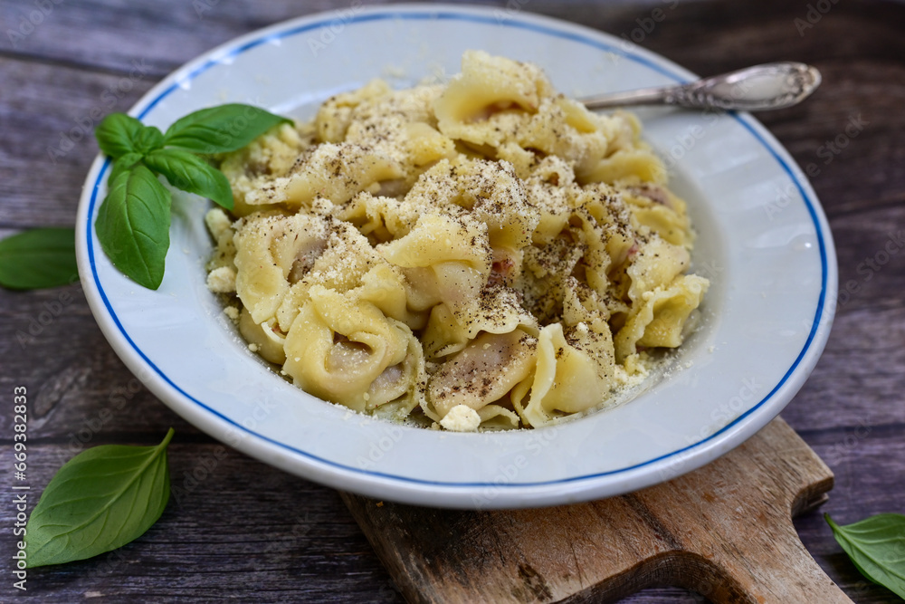 Home made Italian Tortelloni bolognese with parmesan cheese filled with beef , tomato and mozzarella cheese, decorated with fresh basil Home made Italian Tortelloni bolognese with parmesan cheese filled with beef , tomato and mozzarella cheese, decorated with fresh basil