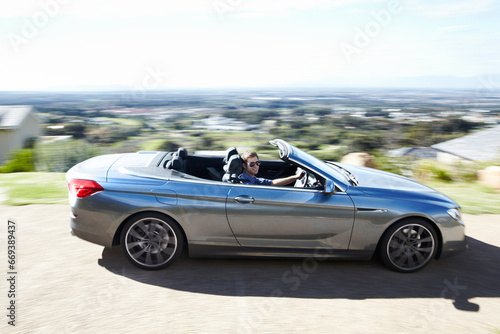 Blur, smile or man drive sports car on road, travel or journey outdoor on trip. Happy person with sunglasses in motor vehicle, speed or fast on street for freedom in luxury convertible transportation © Duncan M/peopleimages.com