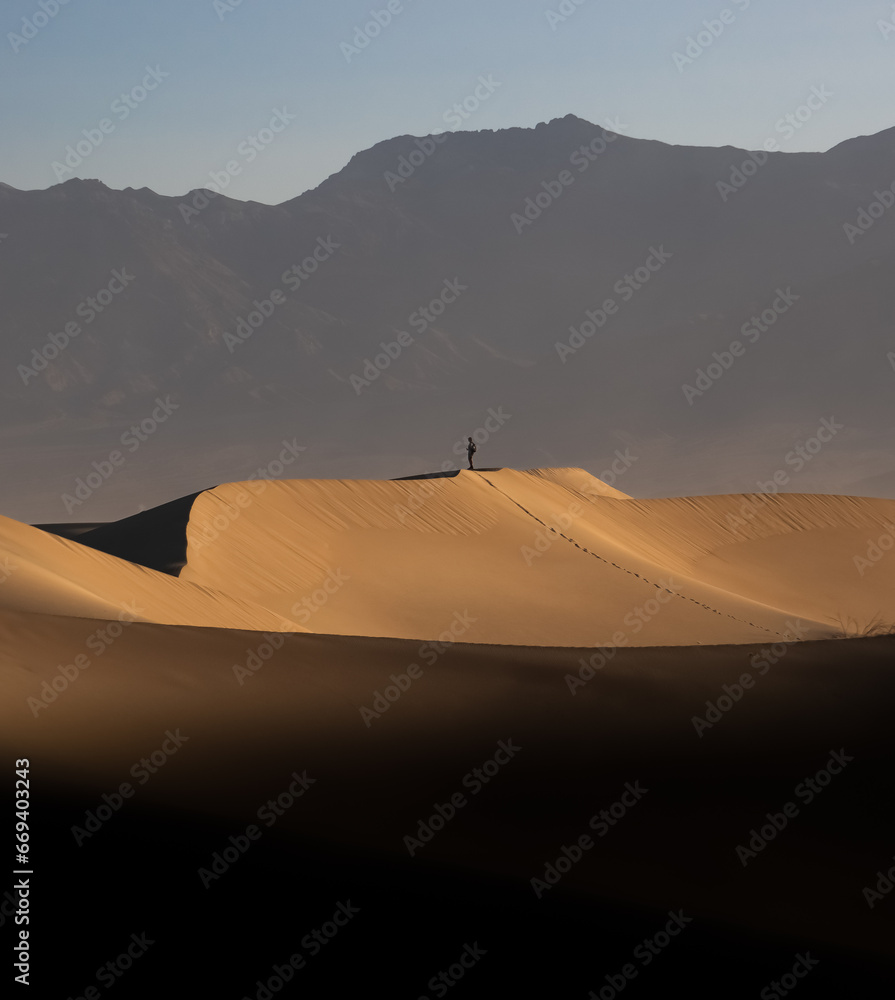 Lone man on a sand dune in Death Valley, California, USA.