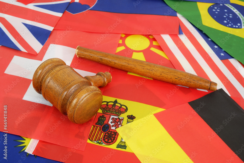 International laws problems concept. Broken wooden judge gavel on national flags.