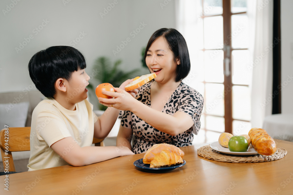 Happy family having breakfast in kitchen.Asian family making food in kitchen on table at home . Happy family having breakfast in kitchen.Asian family making food in kitchen on table at home .