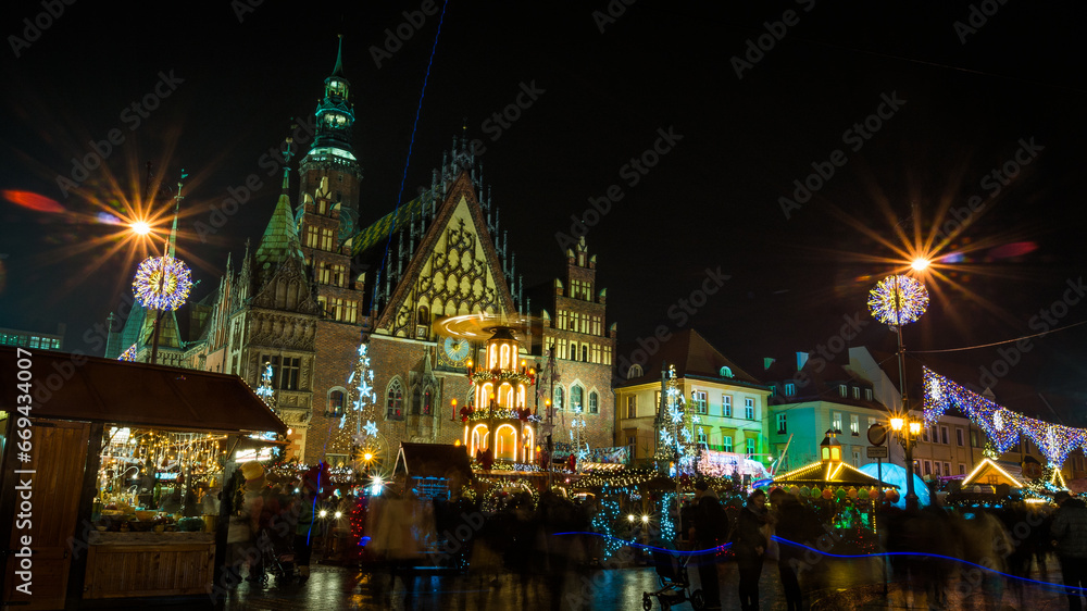 Christmas magic in Wroclaw, Poland. Illuminated market square with vibrant lights, bustling crowd, and historic architecture. A long exposure brings life and movement.