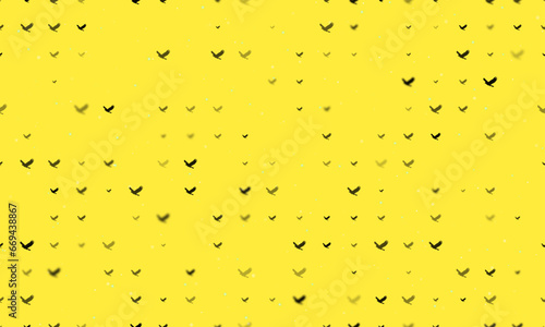 Seamless background pattern of evenly spaced black eagle symbols of different sizes and opacity. Vector illustration on yellow background with stars