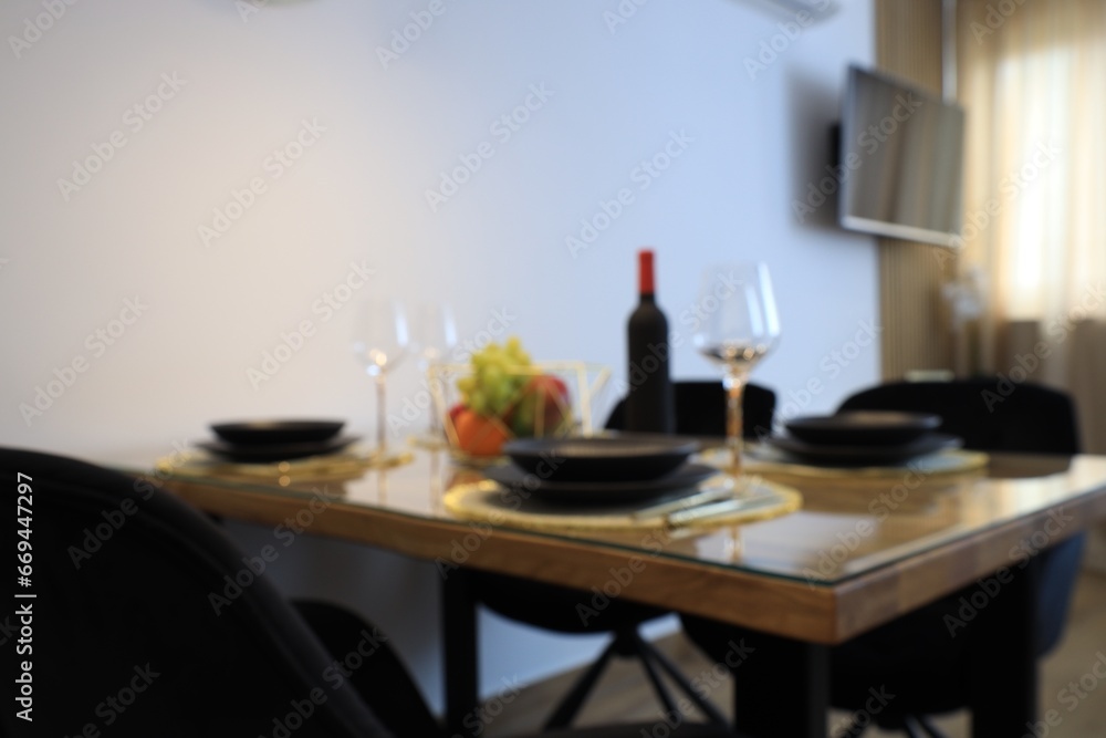Blurred view of elegant table setting for dinner indoors