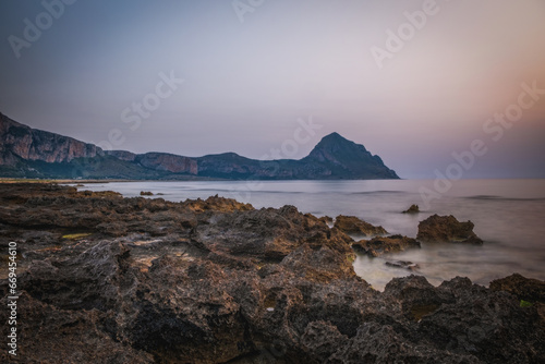 Italy,Sicily,Trapani district,San Vito Lo Capo,Mediterranean sea, Tyrrhenian sea,Gulf of Macari Makari illuminated in red in the early evening lights. June 2023