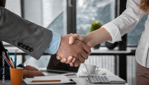 lose up of handshake in the office,young businesspeople shaking hands