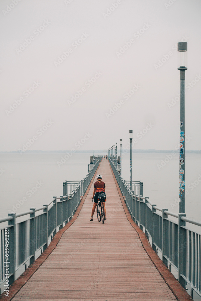 pier on the beach with a cyclist pier on the beach with a cyclist