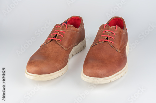 Pair of men's leather shoes in light brown color isolated on a white background