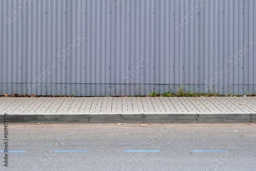 Gray metal fence along the sidewalk