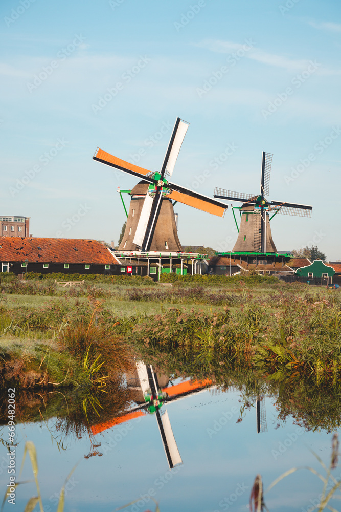 Fototapeta premium Popular tourist spot Zaanse Schans is near Amsterdam in the west of the Netherlands. Historical, realistic windmills during sunrise. Holland's landmark
