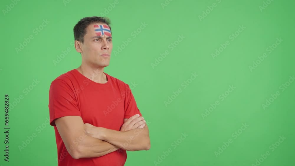 Man with norwegian flag painted looking away with serious expression Man with norwegian flag painted looking away with serious expression