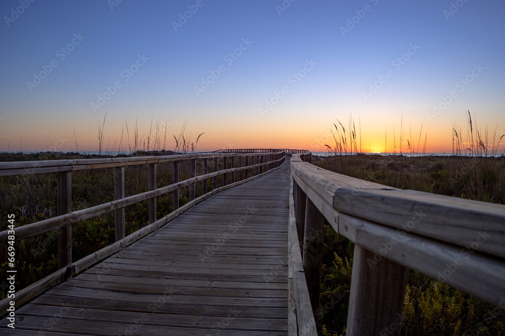 Wooden walkway at sunrise in the Salinas de San Pedro regional park in the Region of Murcia, Spain