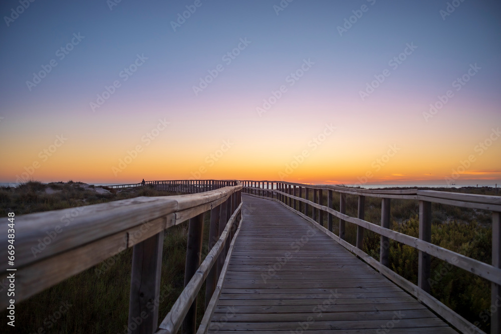 Wooden walkway at sunrise in the Salinas de San Pedro regional park in the Region of Murcia, Spain