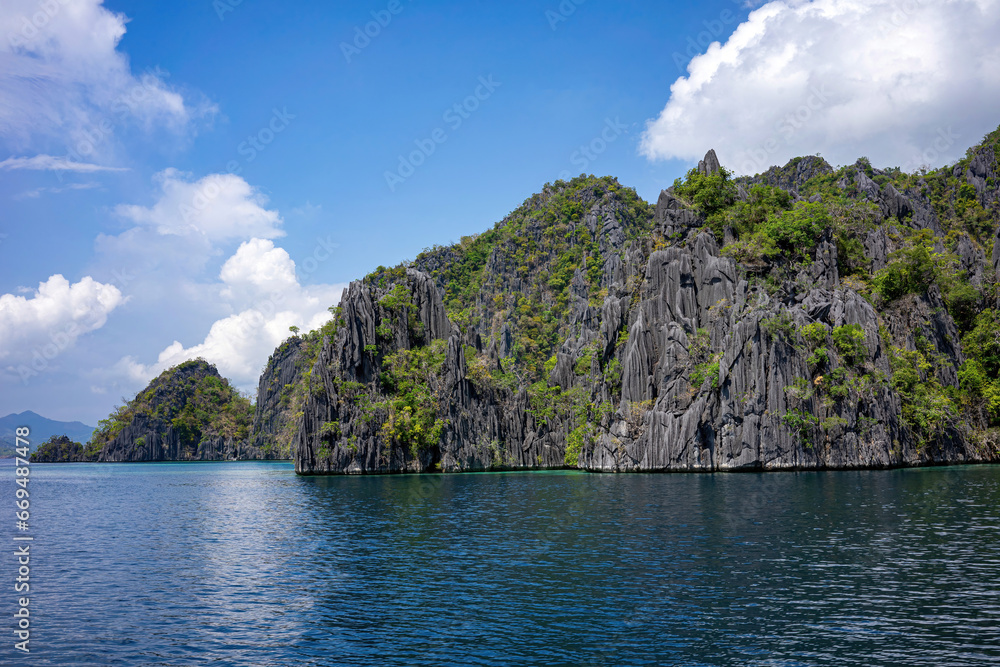 Naklejka premium Majestic limestone formations towering over serene blue waters