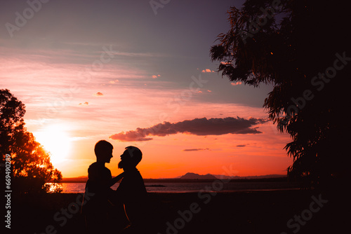 Father and son playing in the park at the sunset time. People having fun on the field.