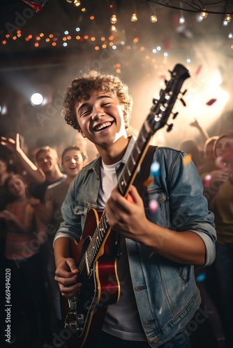 Portrait of a cheerful young man playing the guitar at a music festival