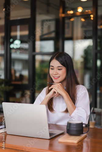 Businesswomen reading data on laptop to analysis about new startup while working in outside office