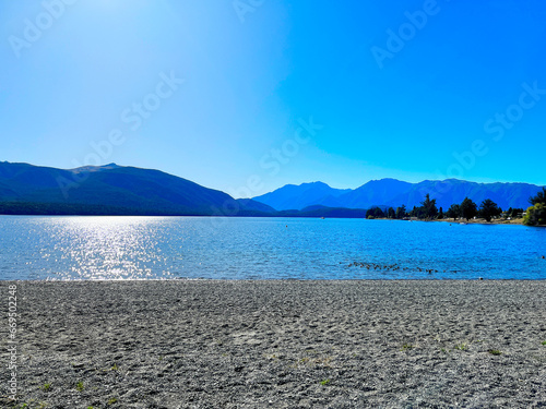 Beautiful Lake TeAnau and sun in New Zealand photo