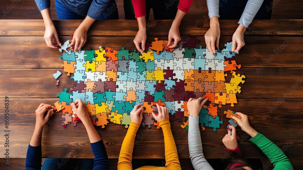 People putting together jigsaw puzzle. Top view shot People putting together jigsaw puzzle. Top view shot