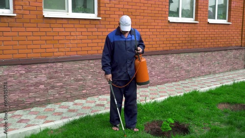 Wallpaper Mural A man works in the garden, spraying weeds from a sprayer Torontodigital.ca