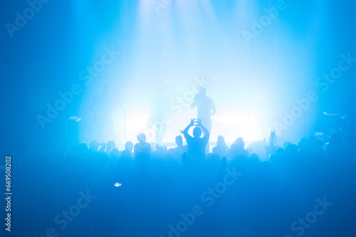 Man shoe heart by gesture during rock concert performance, wide angle
